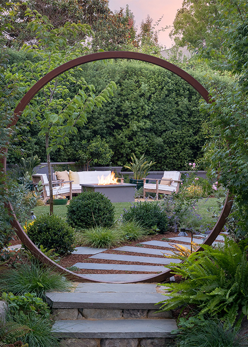 circular gate around a pathway with firepit lounge area in background