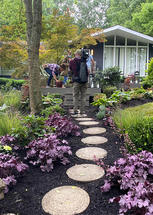 a tv crew films while crew and cast of curb appeal xtreme complete the staging of the front yard makeover