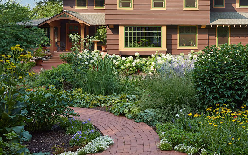 brown home with cottage garden in front yard