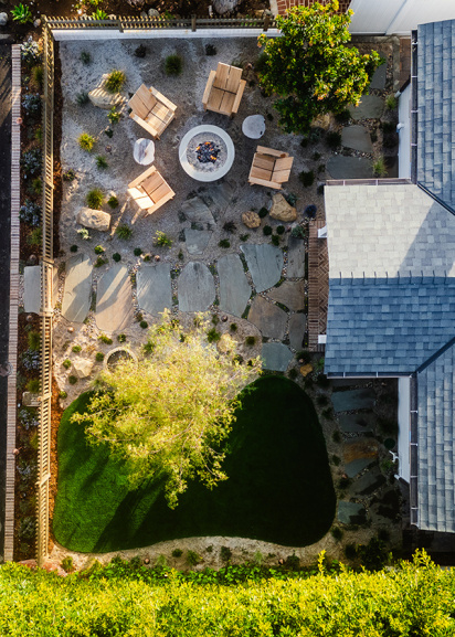 birds eye view of front yard, with fire pit and seating area at the top, a pathway through the middle, and a turf lawn on the bottom