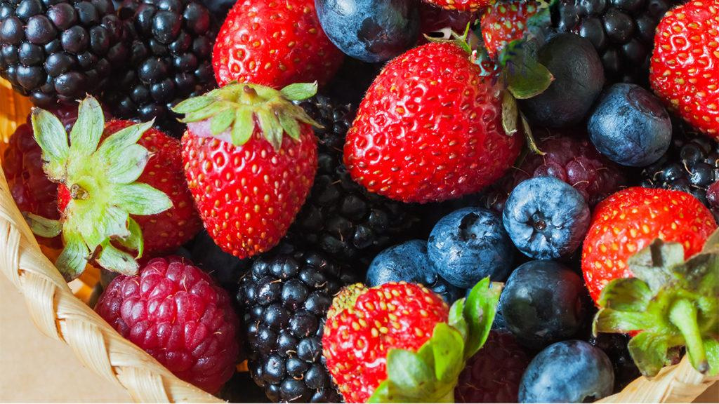 Close-up of a bowl of berries including strawberries, blueberries, raspberries, and blackberries.