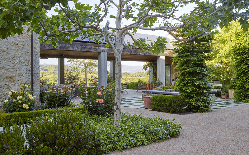 mediterranean-inspired breezeway with trees and roses